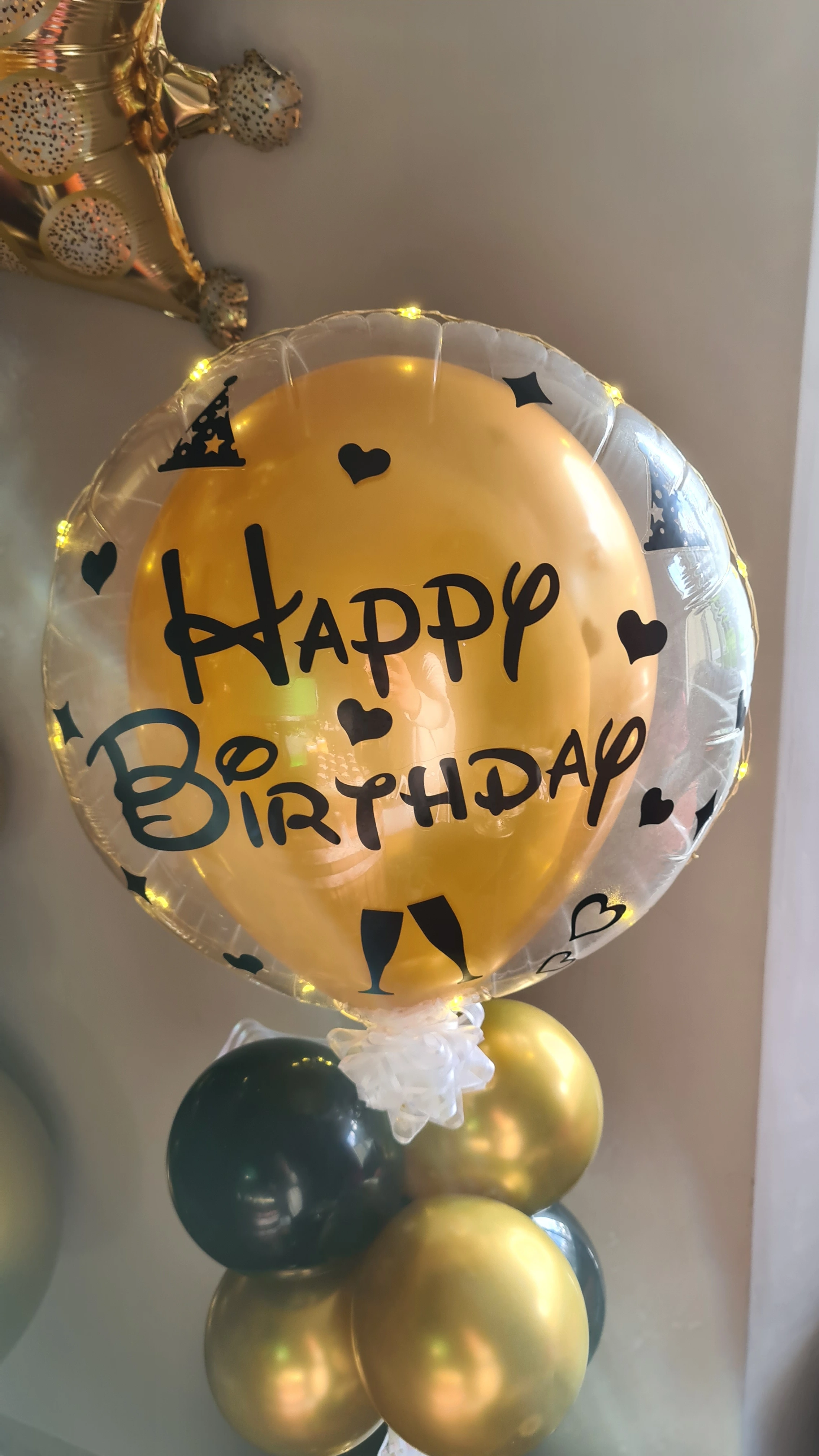 golden balloon inside of a bigger happy birthday balloon