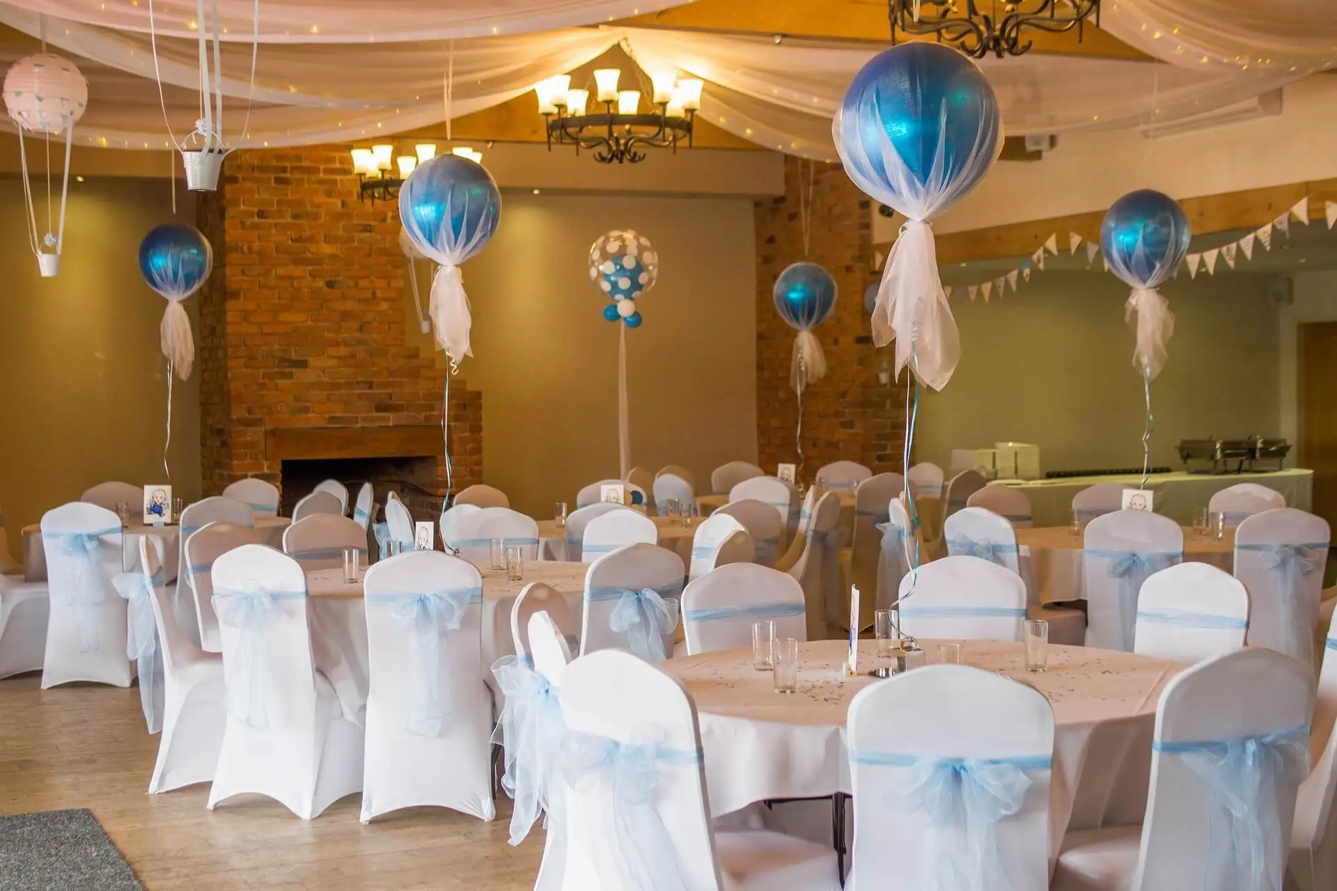 blue helium balloons wrapped on clote above white chairs and tables